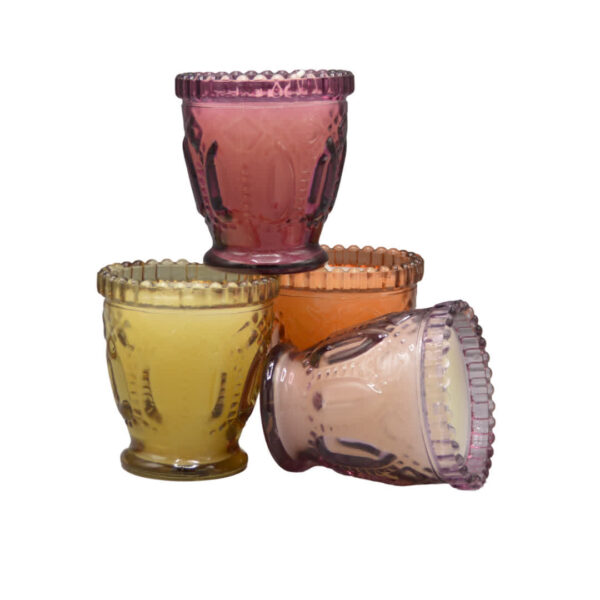 Ronde Dijk kaars in glas met geel, oranje en roze tinten, sfeervol op tafel geplaatst