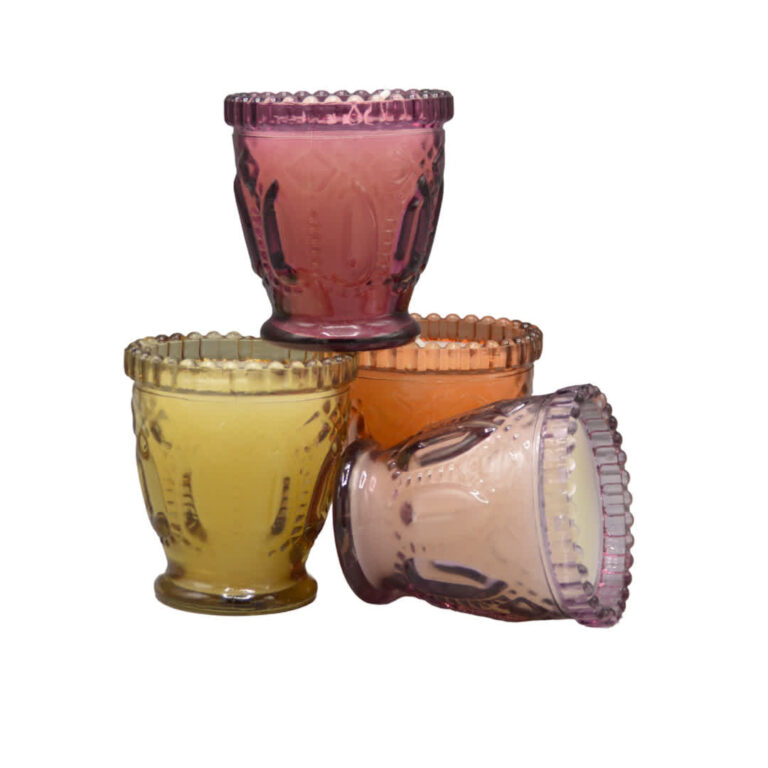 Ronde Dijk kaars in glas met geel, oranje en roze tinten, sfeervol op tafel geplaatst